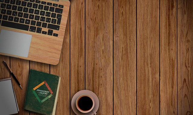 Web design and coding work in progress on a MacBook with reference materials